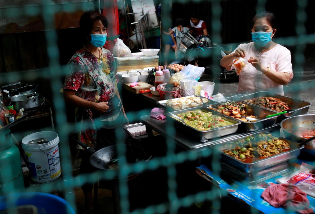 Vendors wearing protective face masks sell foods in a market in Bangkok on April 11, 2020. Thailand has reported a total of 2,579 cases and 40 fatalities. (Reuters)