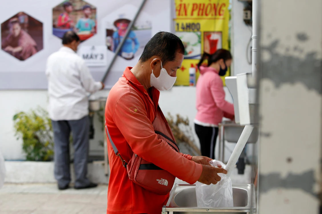 Residents hit by the coronavirus outbreak get rice from a 24/7 automatic rice dispensing machine in Ho Chi Minh, Vietnam on April 11, 2020. (Reuters)