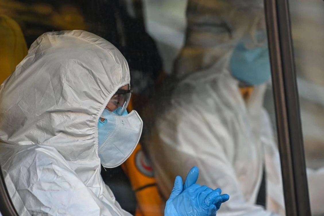 First aid workers wearing protectional equipment sits in an ambulance on April 12, 2020 in Istanbul, during a two-day curfew to prevent the spread of the epidemic COVID-19 caused by the novel coronavirus. (AFP)