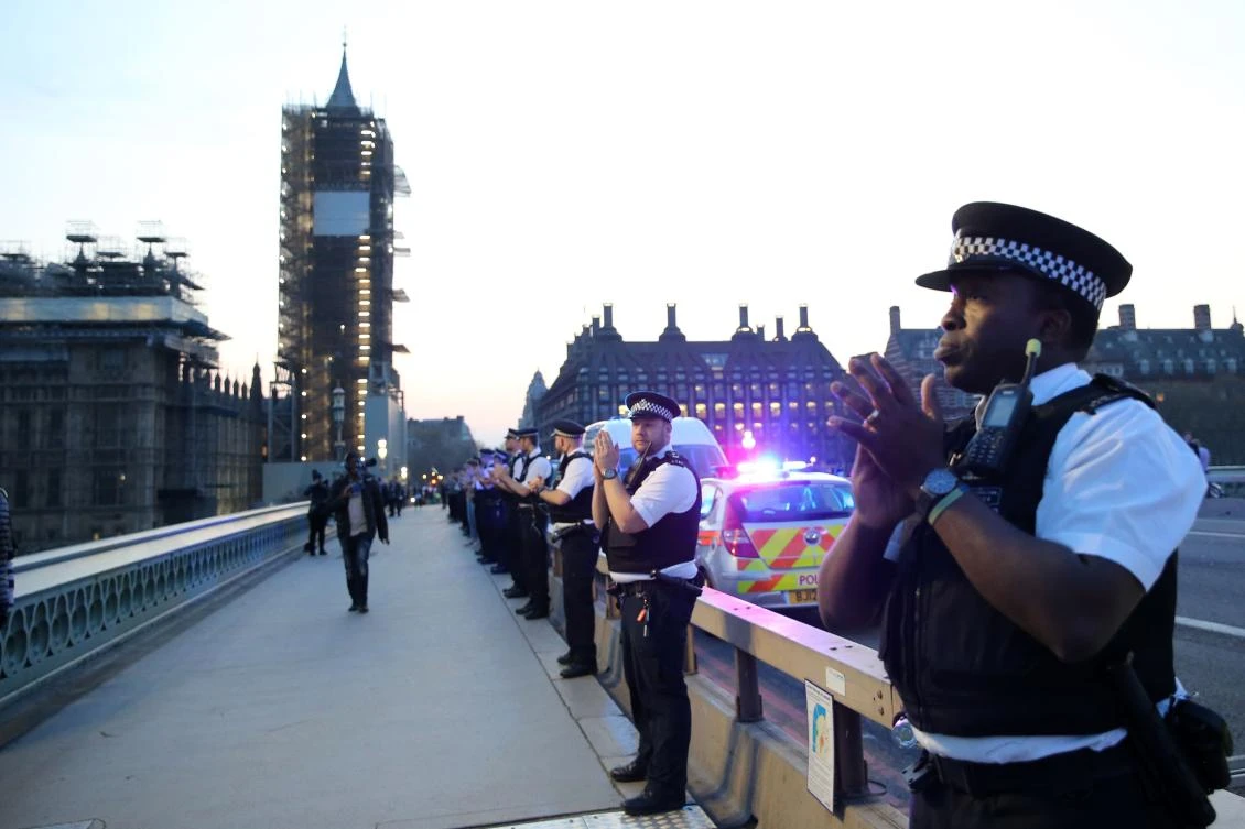 Police officers take part in a national "clap for carers" to show thanks for the work of Britain's National Health Service (NHS) workers and frontline medical staff around the country as they battle with the novel coronavirus pandemic, on Westminster Bridge in London on April 9, 2020. (AFP)
