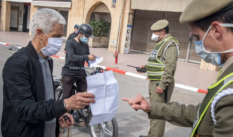 Moroccan authorities wearing protective masks check people at a road block in a street in the capital Rabat on April 9, 2020 during the coronavirus COVID-19 pandemic crisis. (AFP)