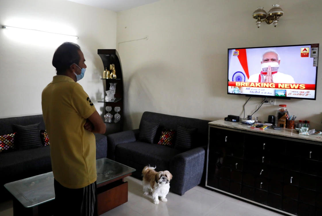 A resident watches India’s Prime Minister Narendra Modi’s address announcing the extension of a nationwide lockdown until May 3. The number of people infected with coronavirus in India had reached 10,363, with 339 deaths. (Reuters)