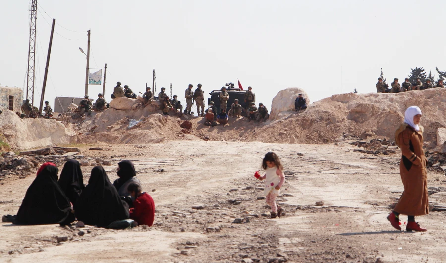 Turkish army troops take position behind sand barricades aimed at blocking the road by Syrian protesters on the M4 highway, which links the northern Syrian provinces of Aleppo and Latakia, in opposition of joint Turkish-Russian military patrols near the the village of al-Nayrab in Syria's jihadist-controlled northwestern Idlib province on April 13, 2020. (AFP)