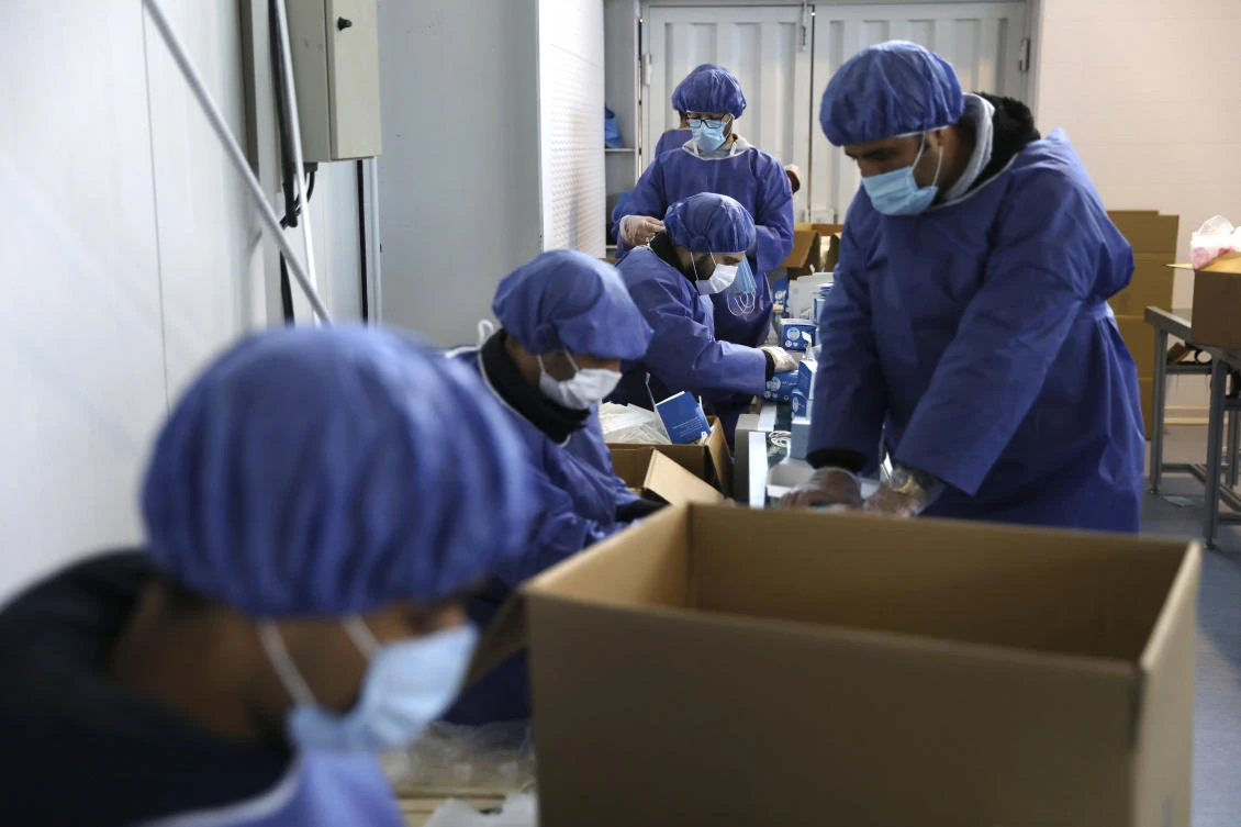 Iran, the Middle Eastern country hardest hit by the outbreak, has a total of 76,389 people infected. Above, workers wearing protective suits pack face masks at a factory in Eshtehard, west of Tehran. (AP)