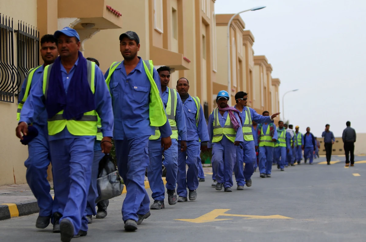 Migrant workers return to their accommodation from the construction site of Al Janoub Stadium in Al Wakrah, Qatar. (AFP)
