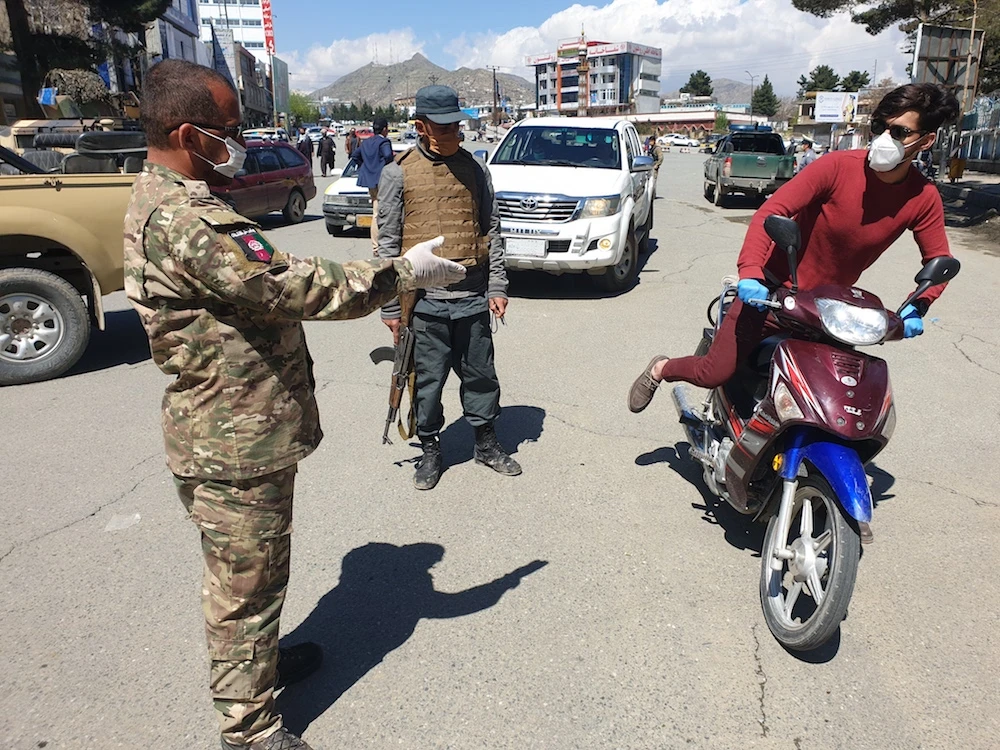 A police officer stops a man for riding motorbike in Kabul where government announced on Wednesday an indefinite ban on use of motorcycles following a rise in criminal acts and assassinations, conducted mostly by people riding these machines. (AN photo)