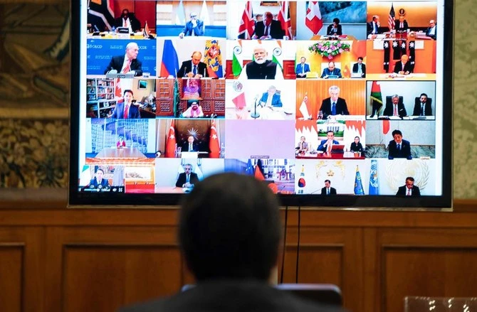 This photo taken and handout by the press office of Palazzo Chigi on March 26, 2020 shows Italian Prime Minister, Giuseppe Conte (L) taking part in a video conference as part of an extraordinary meeting of G20 leaders, from the Chigi Palace in Rome, during the country's lockdown following the COVID-19 new coronavirus pandemic. (AFP)