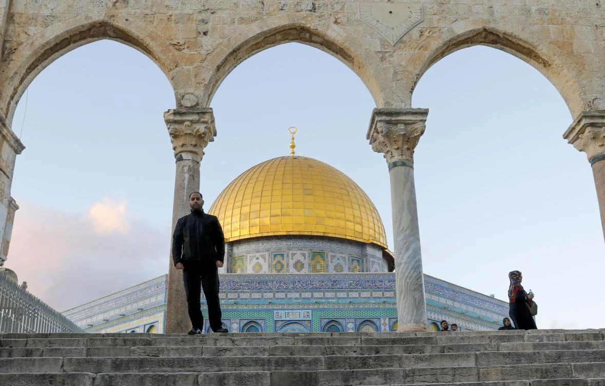 Muezzin Firas al-Qazzaz, who calls Muslims to prayer, poses for a picture in front of the Dome of the Rock mosque at Al-Aqsa compound in Jerusalem's Old City, on December 2, 2019. (AFP)