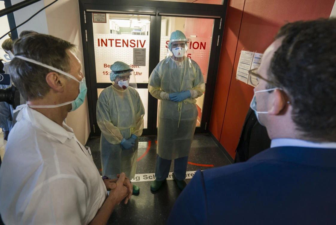 German Health Minister Jens Spahn, right, talks healthcare frontliners of the University Hospital of Giessen and Marburg in Wiesbaden, Germany on April 14, 2020. (DPA via AP)