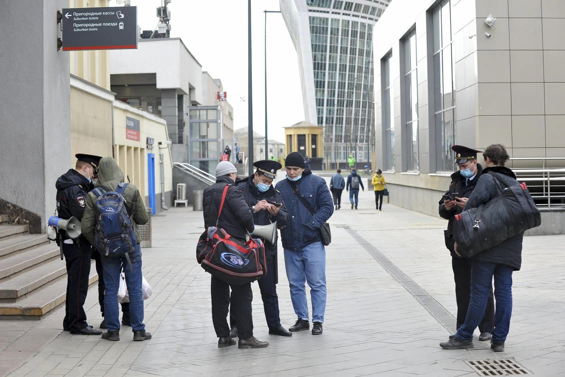 Police officers check electronic passes on people’s smartphones at Kievsky (Kyiv) train station in Moscow on April 15, 2020. (Moscow News Agency via AP)