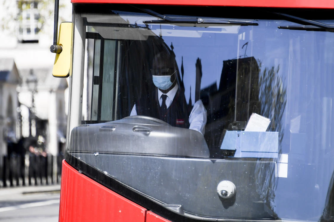 A bus driver wears a protective mask, due to the Coronavirus outbreak, in London, Tuesday, April 14, 2020. (AP/Alberto Pezzali)