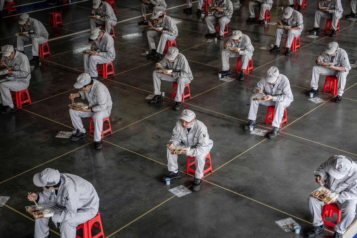Employees eat during lunch break at an auto plant of Dongfeng Honda in Wuhan in China's central Hubei province. (File/AFP)