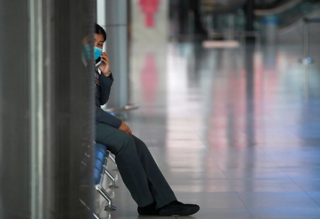 A staff wearing a protective face mask uses her phone at Suvarnabhumi Airport as the government extends a ban on incoming passenger flights until the end of April, following the coronavirus disease (COVID-19) outbreak, in Bangkok, Thailand April 16, 2020. (Reuters)