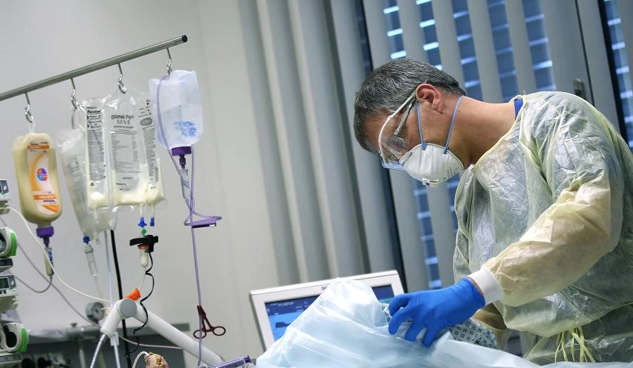 Martin Sauer, head physician for intensive-care medicine, takes care of a Covid-19 patient in the intensive care unit of the community hospital in Magdeburg, eastern Germany, on April 16, 2020 during the novel coronavirus COVID-19 pandemic. (File/AFP)