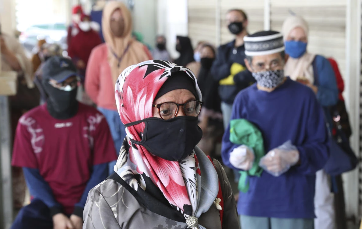 People wearing face masks practice social distancing to help prevent the spread of the coronavirus as they line up at a supermarket in Jakarta, Indonesia, Friday, April 17, 2020. (AP)