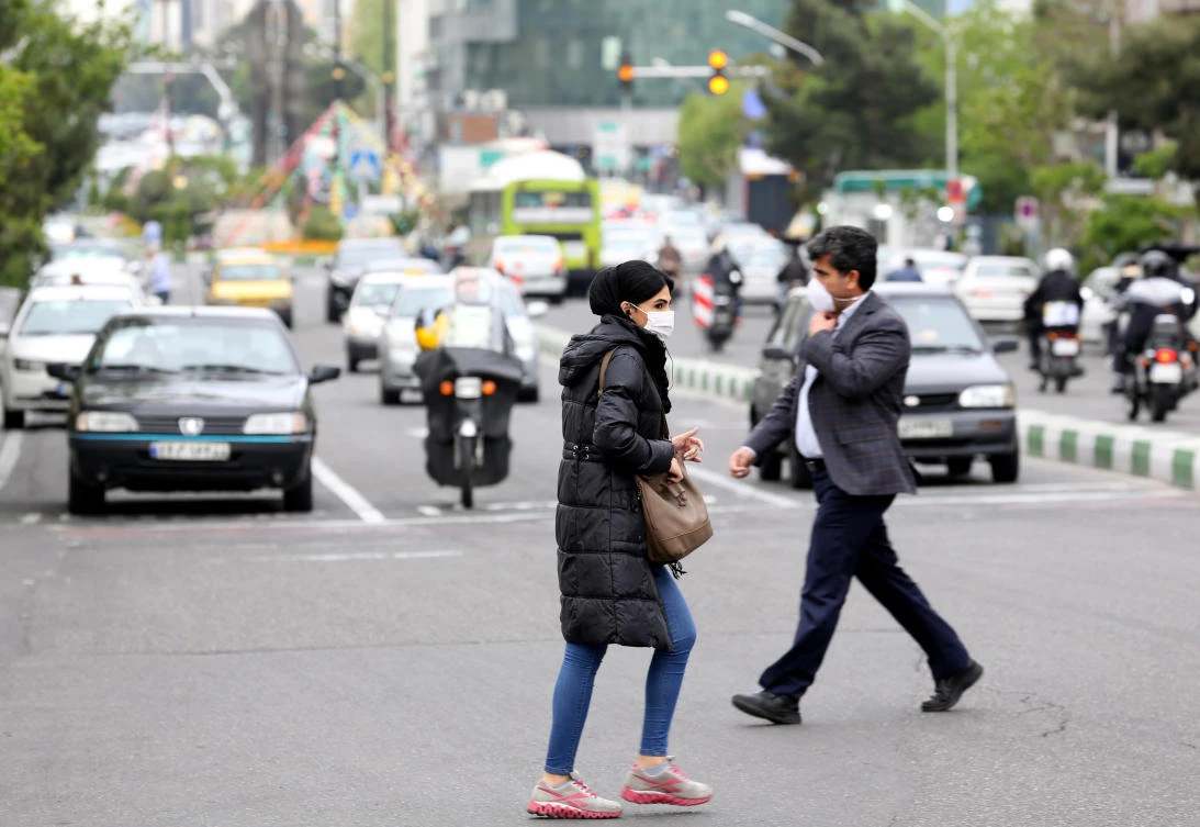 Iranians wearing protective masks cross a main road in Tehran on April 13, 2020 during the coronavirus COVID-19 pandemic. (AFP)