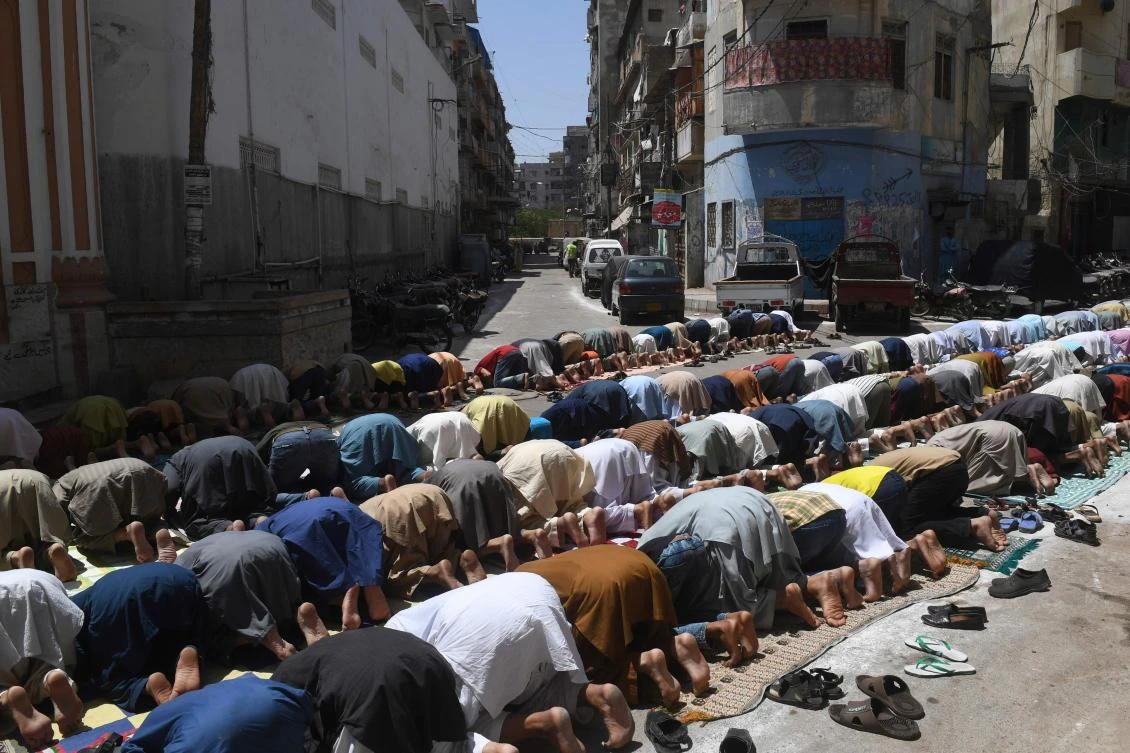 Muslim devotees offer Friday prayers outside a closed mosque during a government-imposed nationwide lockdown as a preventive measure against the COVID-19 coronavirus, in Karachi on April 17, 2020. (AFP/Asif Hassan)