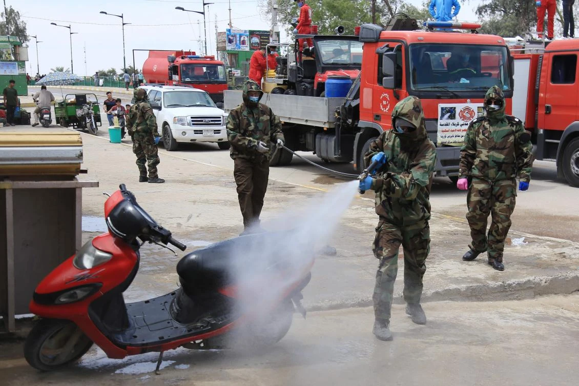 Iraqi civil defence workers sanitize the Tweirij district between Hilla and the southern Iraqi shrine city of Karbala against the spread of the coronavirus pandemic, on April 16, 2020. (AFP)