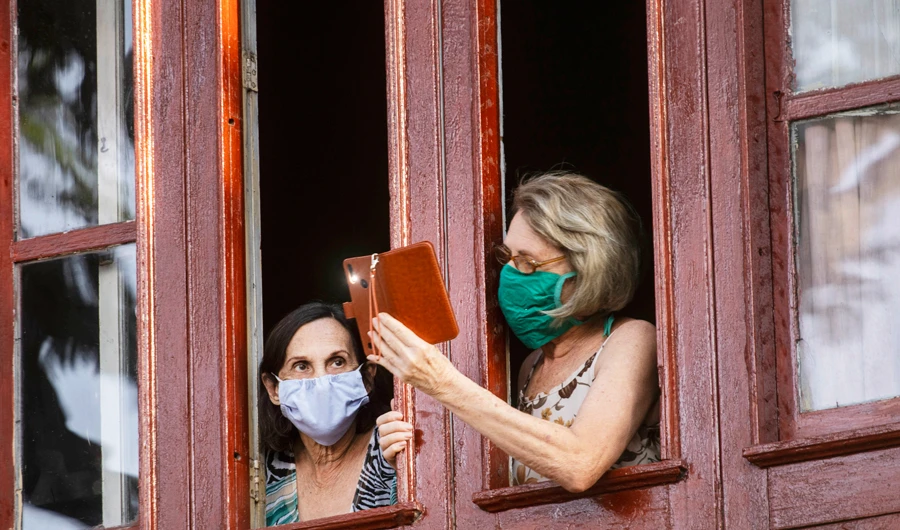 Women watch outside a window as Cuban soldiers (not seen) clean the streets with a bleach solution in Havana, Cuba. (AP)