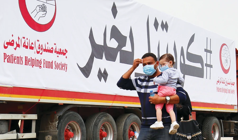 A man and a toddler arrive at a screening zone in Kuwait. (AFP)