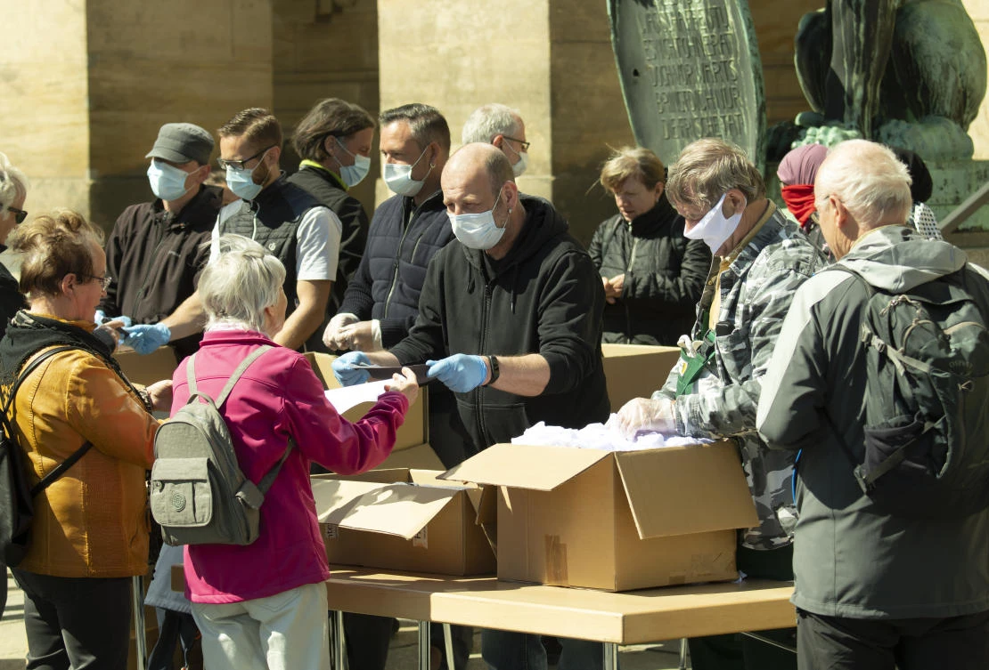 City administration helpers hand out face masks in Dresden. Germany reported on Tuesday April 20, 2020 that coronavirus death toll rose by 194 to 4,598. (AP)