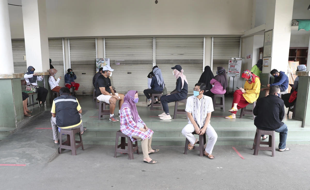 Above, people wears face masks as they practice social distancing to prevent the spread of the new coronavirus in Jakarta. More than 46,700 people have been tested and 842 people had recovered in Jndonesia. (AP)