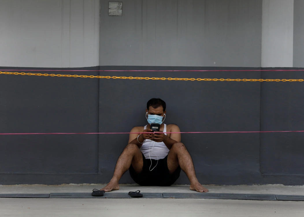 Singapore has seen a sharp jump in cases in recent weeks fueled by infections in cramped migrant worker dormitories. Above, an expat worker outside his dormitory. (Reuters)