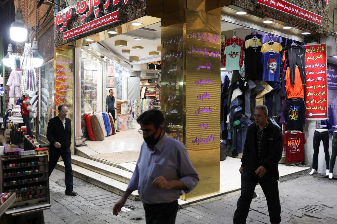 People walk past open stores after shopping malls and bazaars reopened in Tehran on April 20, 2020. (West Asia News Agency via Reuters)