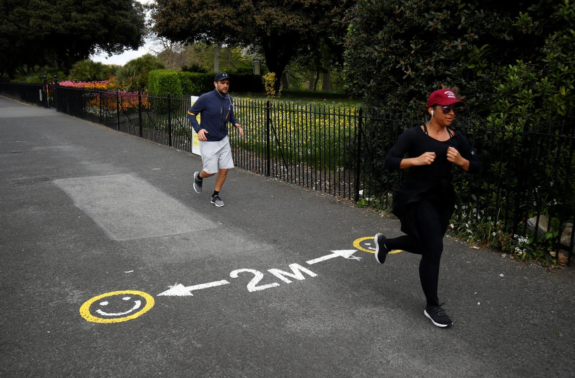 Two people jog past a social distance marker, as the spread of the coronavirus disease (COVID-19) continues, Dublin, Republic of Ireland, April 21, 2020 (Reuters)