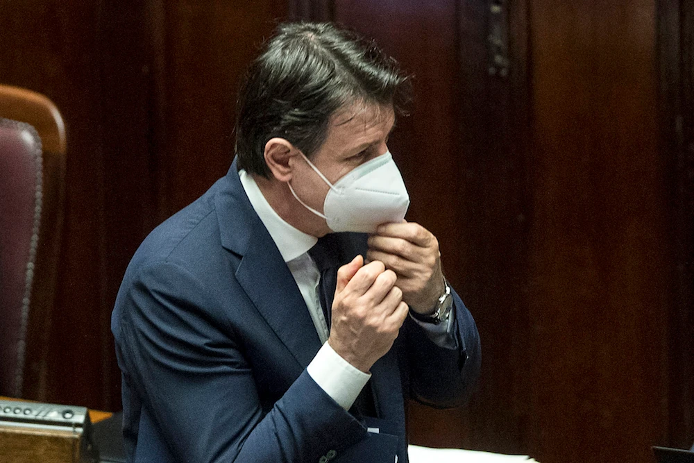 Italian Premier Giuseppe Conte adjusts his face mask as he arrives at the Lower Chamber of Deputies of the Italian Parliament, in Rome, Tuesday, April 21, 2020. (AP)