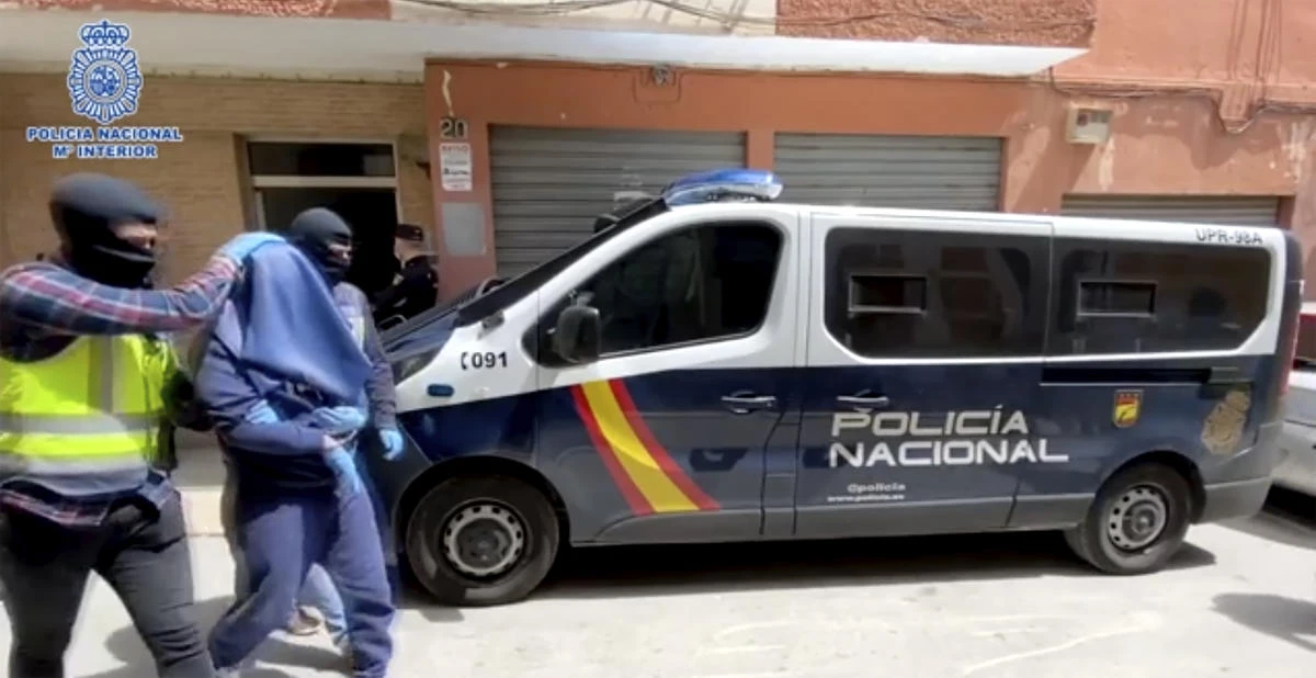 In this photo taken from video released by Spanish National Police, showing police escorting suspected Egyptian extremists detained in a Monday overnight raid, in Almeria, Spain, Tuesday April 21, 2020. (Spanish National Police via AP)