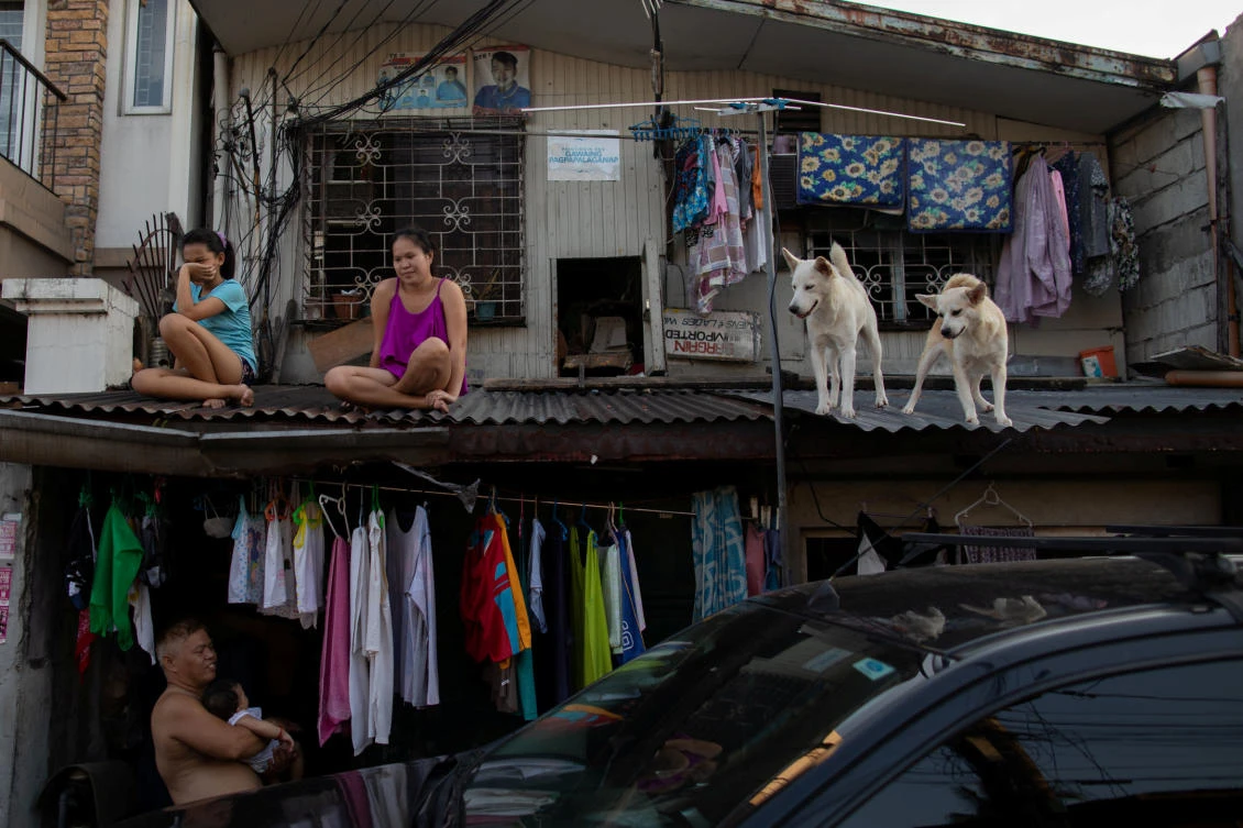 Residents hang out with their dogs on the roof of their house as the Philippine government enforces home quarantine to contain the coronavirus disease outbreak in Metro Manila on April 21, 2020. (Reuters)