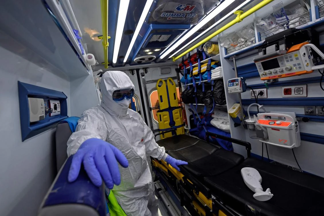 A healthcare worker rides an ambulance to pick up a person who has fallen ill in Madrid on April 19, 2020. (AFP)