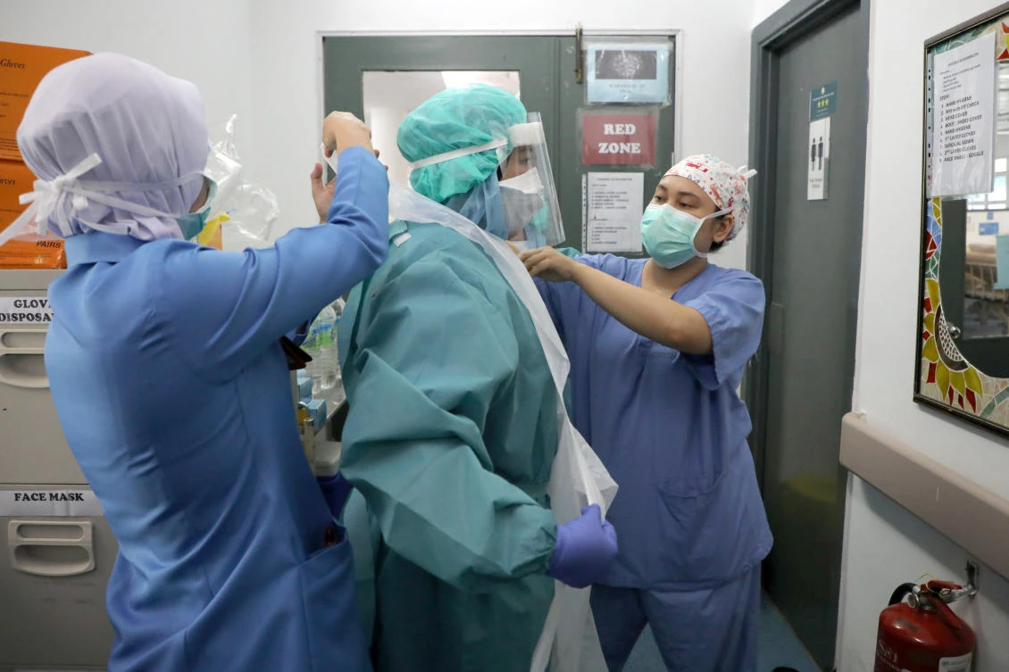 Nurses help each other to put on a protective equipment before entering the coronavirus disease ward at Kuala Lumpur Hospital, in Kuala Lumpur, Malaysia on April 21, 2020. (Reuters)