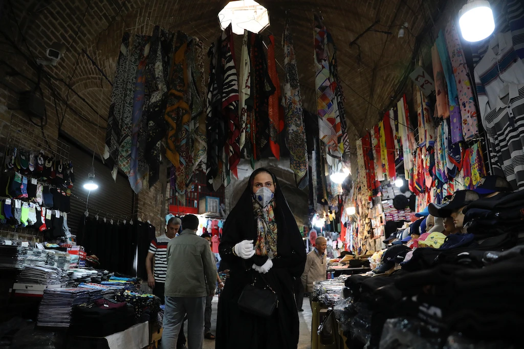 A woman wearing a protective face mask and gloves to help prevent the spread of the coronavirus, walks through the Qazvin old traditional bazaar some 93 miles (150 kilometers) northwest of the capital Tehran Iran, Wednesday, April 22, 2020. Iran is the COVID-19 hardest-hit country in the Mideast and one of the world's worst outbreaks of the new coronavirus. (AP)