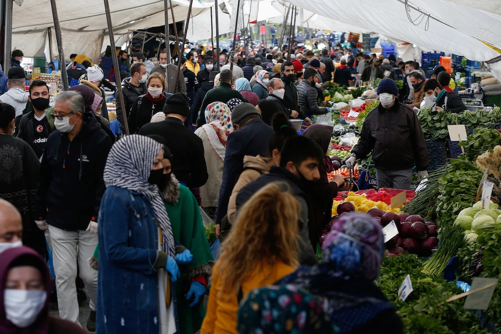 Local residents, most wearing face masks as a preventive measure against the spread of the coronavirus, shop in an open market in Istanbul, April 22, 2020. (AP Photo)
