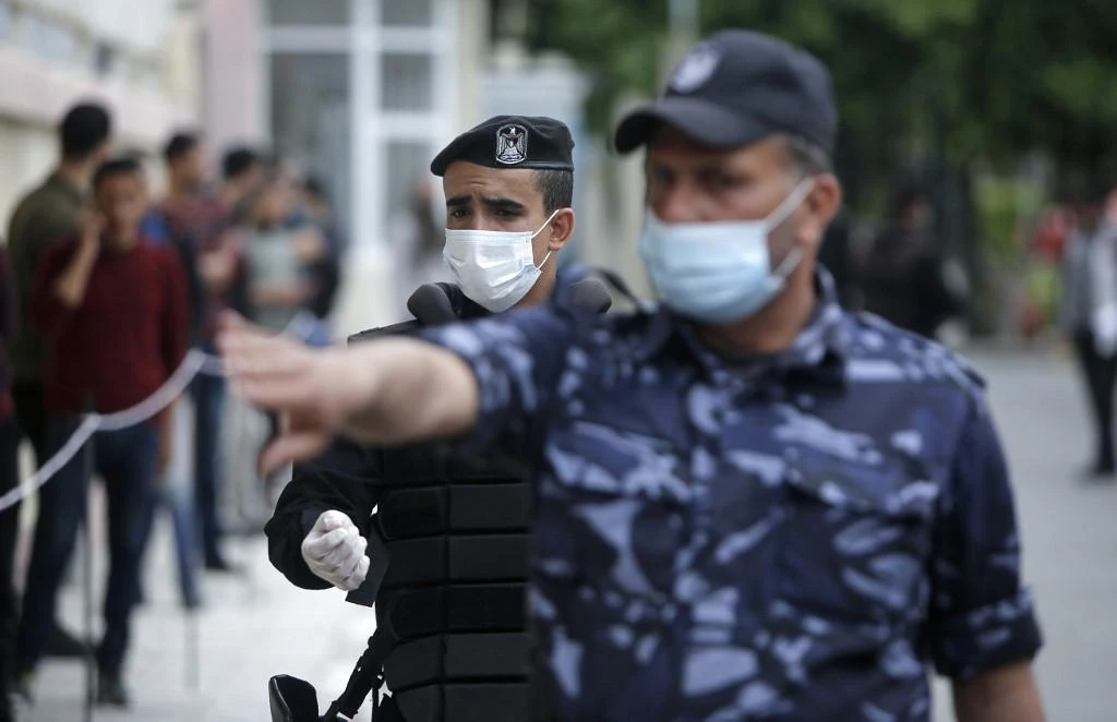 Above, Palestinian policemen impose coronavirus lockdown measures in Gaza City on March 31, 2020. (AFP)