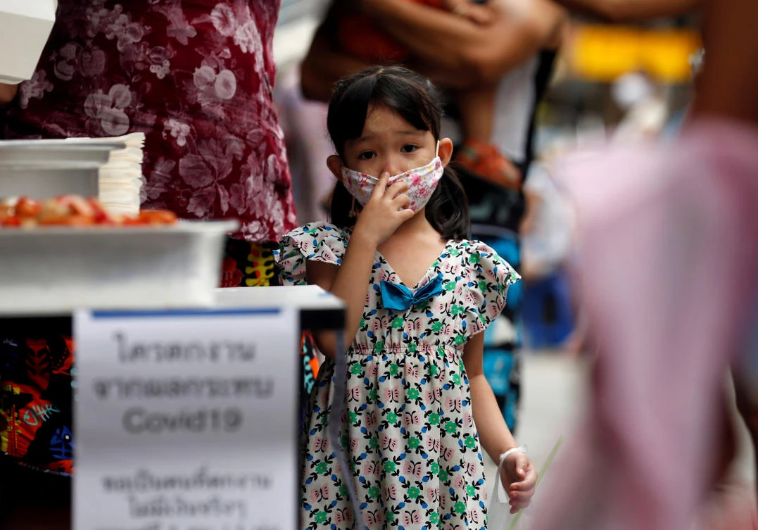 Since the outbreak 2,490 patients in Thailand have recovered and gone home. Above, a girl lines up for free foods from volunteers in Bangkok on Thursday, April 23, 2020. (Reuters)