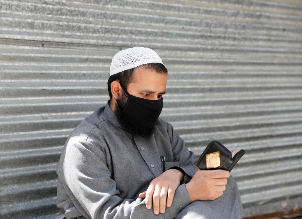 An Afghan man reads the Koran on the first day of the holy fasting month of Ramadan in Kabul on April 24, 2020. (Reuters)
