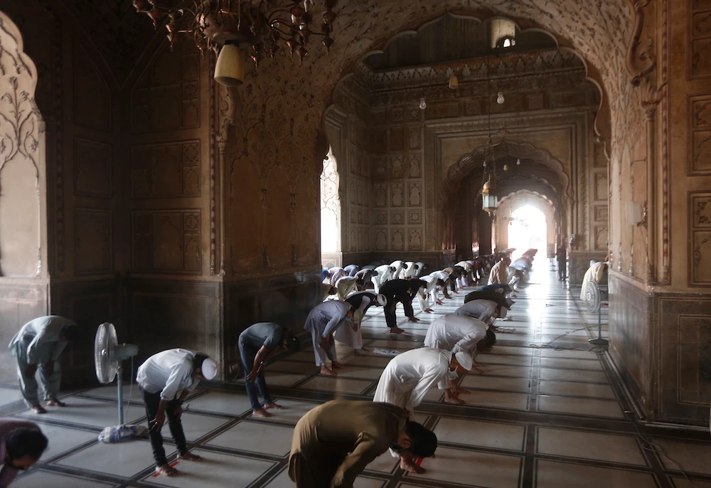 People attend Friday prayers at the historic Badshahi mosque while maintaining a level of social distancing to help avoid the spread of the coronavirus, in Lahore, Pakistan, April 24, 2020. (AP Photo)