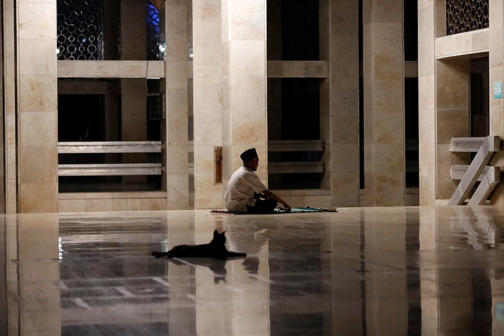 A man prays in the corridor of the Great Istiqlal mosque, closed during the imposition of large-scale COVID-19-realted restrictions by the government, in Jakarta, Indonesia, April 24, 2020. (Reuters)