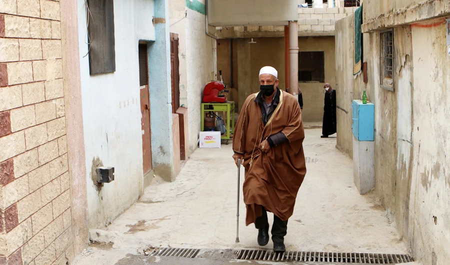An Elderly man wearing a face masks walks through an alley at the Wavel Palestinian refugee camp (also known as the Jalil camp) in Lebanon's eastern Bekaa Valley, on April 24, 2020, after cases of infection by the novel coronavirus were detected there. (AFP)