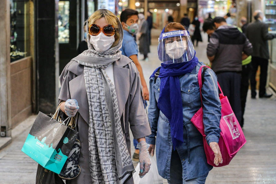 Shoppers clad in protective gear, including face masks and shields and latex gloves, due to the COVID-19 coronavirus pandemic, walk through the Tajrish Bazaar in Iran's capital Tehran on April 25, 2020 during the Muslim holy month of Ramadan. (AFP)