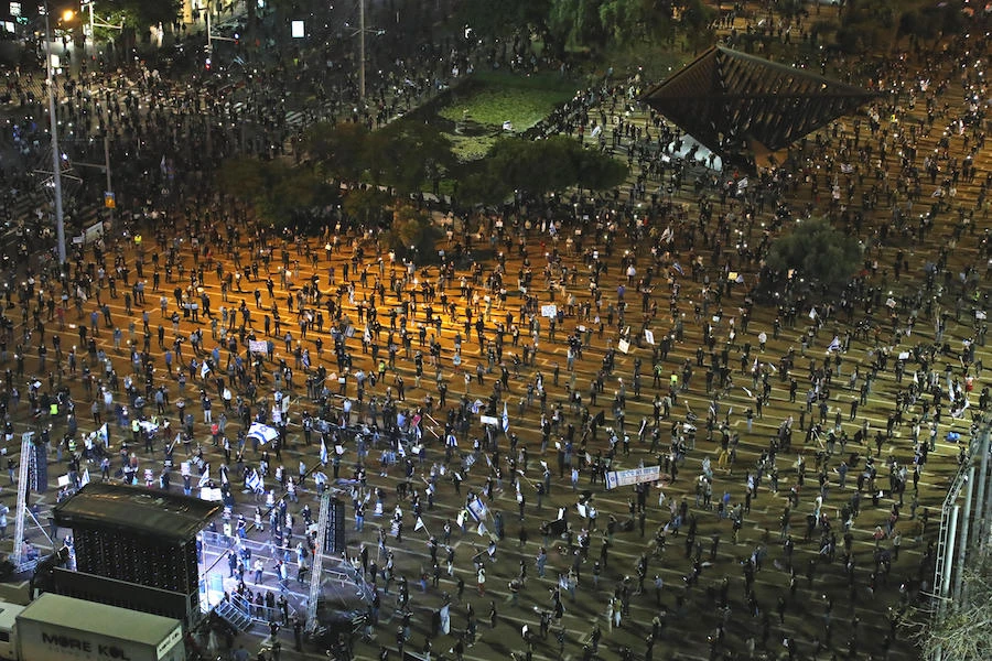 Israelis, keeping at a safe distance from one another, take part in a "Black Flag" demonstration, to protest against Prime Minister Benjamin Netanyahu and anti-democratic measures to contain the novel coronavirus outbreak, at Rabin Square in the coastal city of Tel Aviv, on April 19, 2020. (AFP)