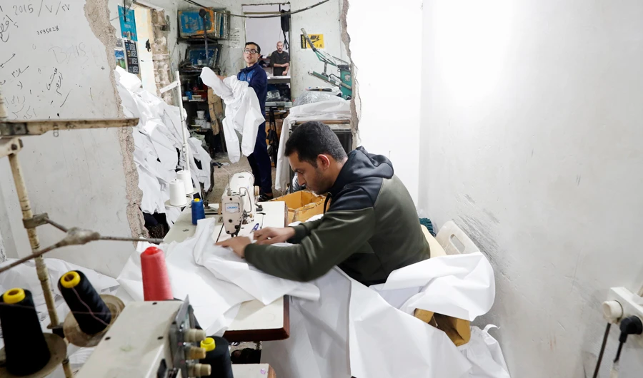 Palestinians make protective overalls to shield people from the coronavirus. Factories in Gaza City are working at full capacity to meet the growing demand for safety equipment. (AP)