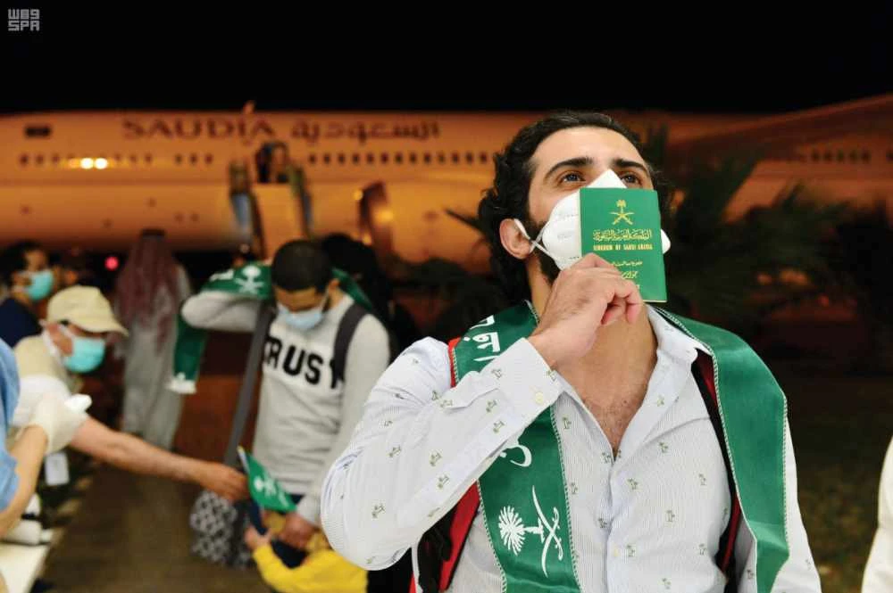 Saudis on a flight from Madrid are welcomed at the airport in Hail province on Saturday. (SPA)