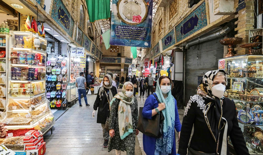 Shoppers clad in protective gear, including face masks and latex gloves, due to the COVID-19 coronavirus pandemic, walk through the Tajrish Bazaar in Iran's capital Tehran on April 25, 2020 during the Muslim holy month of Ramadan. (AFP)