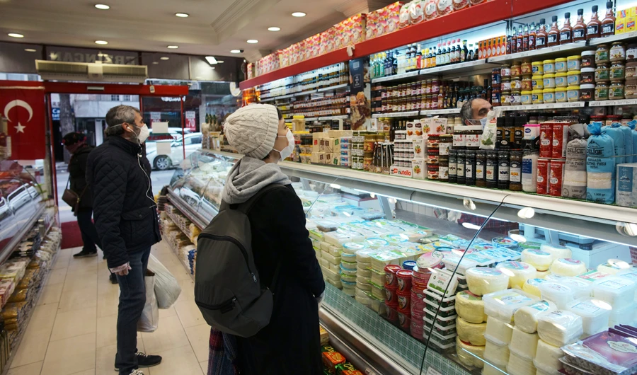 People wearing face masks shop for food at a market in popular Tunali Hilmi Street in Ankara, Turkey, Wednesday, April 22, 2020, just hours before the start of a four-day curfew declared by the government in an attempt to control the spread of coronavirus. (AP)