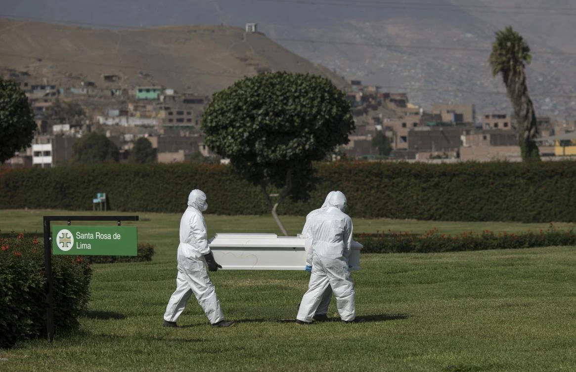 Cemetery workers carry a coffin towards a tomb in Jardines del Buen Retiro cemetery in Lima, Peru, Saturday, April 25, 2020, during the coronavirus outbreak. (AP)