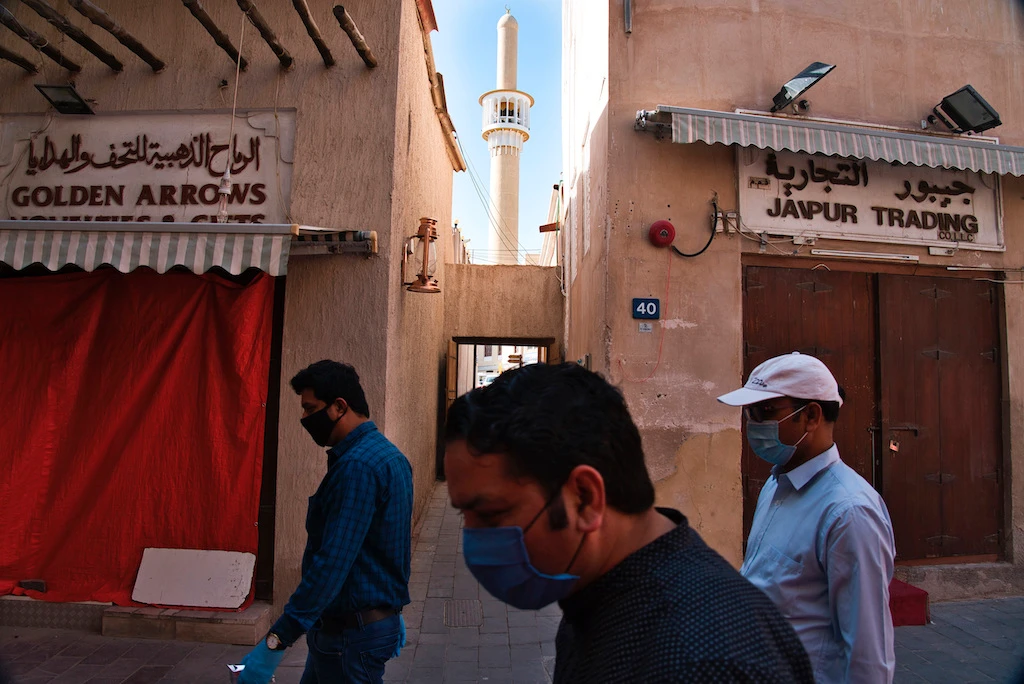 Men in masks and disposable gloves to help curb the spread of the coronavirus, walk through a traditional souq as many shops remain closed due to the outbreak in Dubai, United Arab Emirates, Sunday, April 26, 2020. (AP)